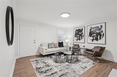 Living room with ornamental molding and wood finished floors