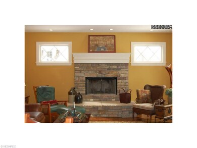 Living room has wood-burning stone fireplace and o