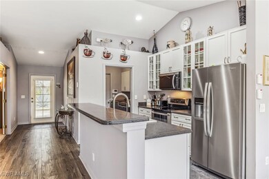 Kitchen with dark tone corian countertops, white c