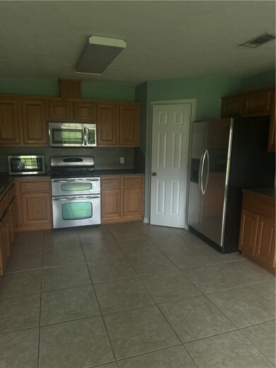 Kitchen featuring stove, refrigerator, dark counte