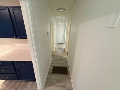 Corridor featuring attic access and light wood-type flooring