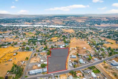 Aerial view of property and surrounding area with property parcel outlined and a nearby body of water