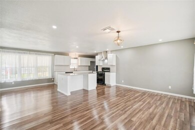 Unfurnished living room featuring light wood-style floors, recessed lighting, baseboards, and a sink