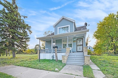 View of front of home with covered porch, a front lawn, and stairs