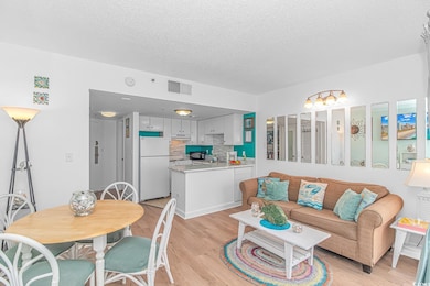 Living area featuring visible vents, light wood-st