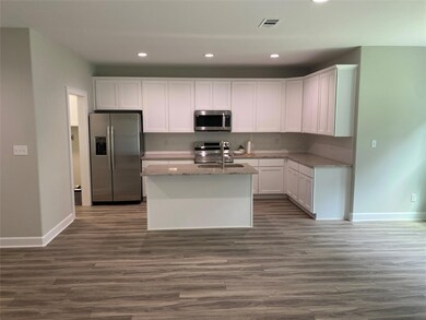 Kitchen featuring a kitchen island with sink, whit