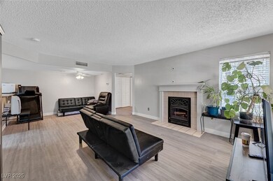 Living room with wood finished floors, a textured
