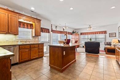 Kitchen with dishwasher, open floor plan, backsplash, a sink, and a kitchen island