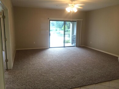 Great room accented with NEW carpet and sliding doors to one of TWO covered patios with lake views.
