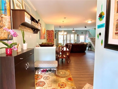 Kitchen with wood finished floors, a chandelier, ceiling fan, hanging light fixtures, and open floor plan