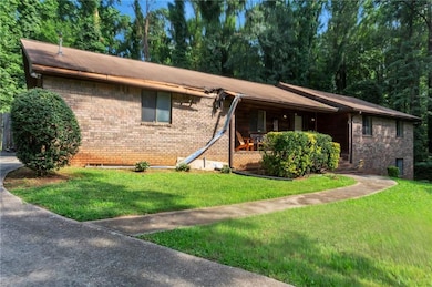 Ranch-style house featuring a front lawn, brick siding, and covered porch