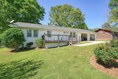 Rear view of house featuring driveway, brick sidin