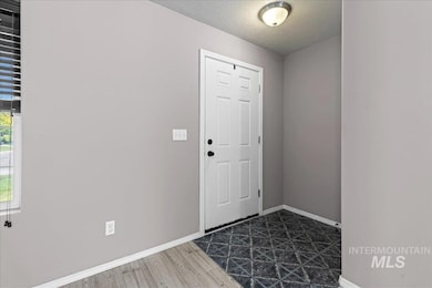Foyer featuring a textured ceiling and dark wood finished floors