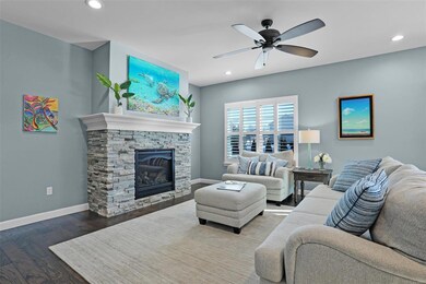 Living room features hardwood floors and stacked stone fireplace.