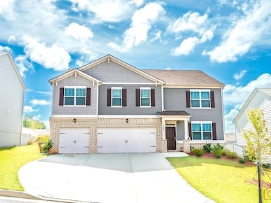 Craftsman-style house featuring brick siding, driveway, and a garage