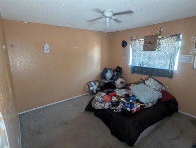 Bedroom featuring ceiling fan, a textured ceiling,