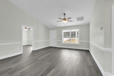 Empty room with ceiling fan, dark wood-type floori