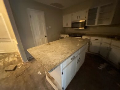 Kitchen with white cabinets, range, and a kitchen 