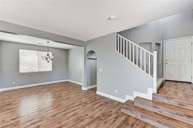 Foyer featuring wood finished floors, arched walkw
