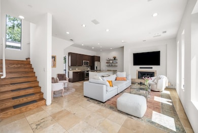 Living area featuring stairway, recessed lighting, and a glass covered fireplace