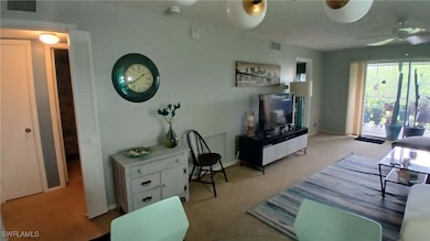 Carpeted living room with ceiling fan