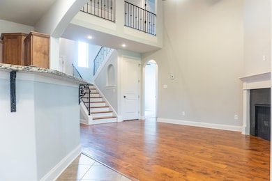Unfurnished living room with stairs, a high ceilin