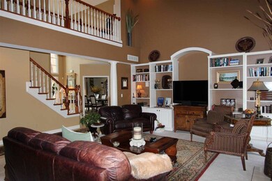The two-story living room has beautiful built-in s