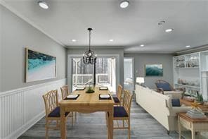 Dining space featuring a chandelier, wood finished floors, recessed lighting, and wainscoting