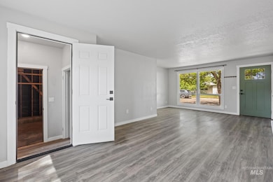 Unfurnished living room with wood finished floors and a textured ceiling