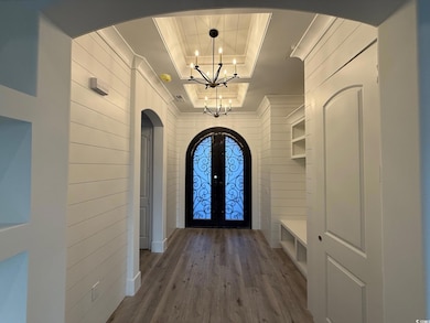 Doorway to outside featuring wood walls, french do