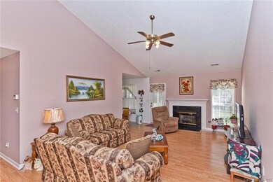 Living room with gas fireplace, vaulted ceiling, a