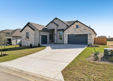 View of front of home with fence, driveway, an at