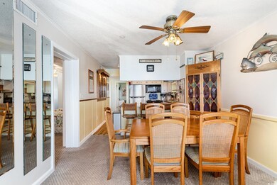 Dining room with light carpet, ceiling fan, crown 