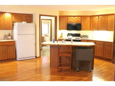 Kitchen with island, hardwood flooring. Half bath 