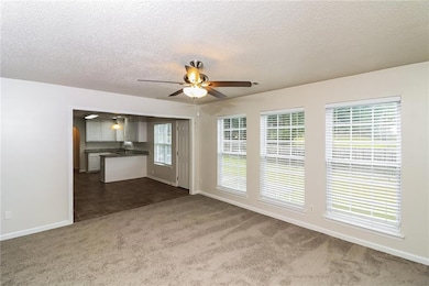 Unfurnished living room with ceiling fan, plenty o