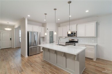 Kitchen with appliances with stainless steel finishes, a sink, baseboards, backsplash, and recessed lighting