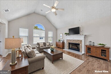 This living room features a vaulted ceiling, a sta