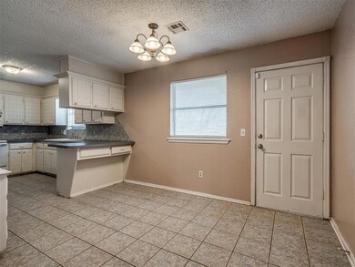Kitchen with an inviting chandelier, backsplash, w