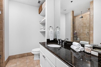 Bathroom featuring a shower stall, vanity, tile p