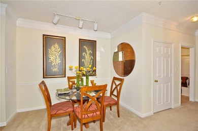 Dining area with crown molding, a textured ceiling