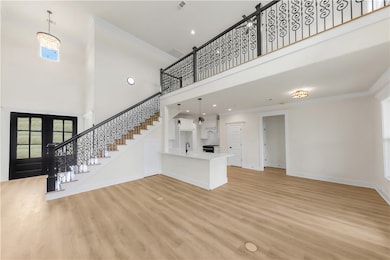 Unfurnished living room featuring a high ceiling,
