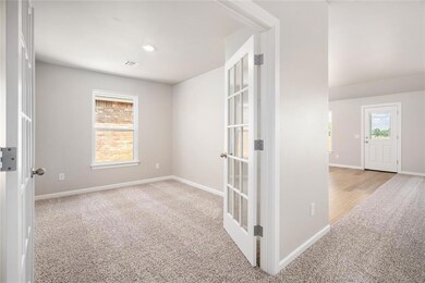 This spacious study featuring gorgeous french doors is the perfect spot for an office or playroom!