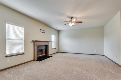 Family room featuring a ceiling fan, light carpet, and a fireplace