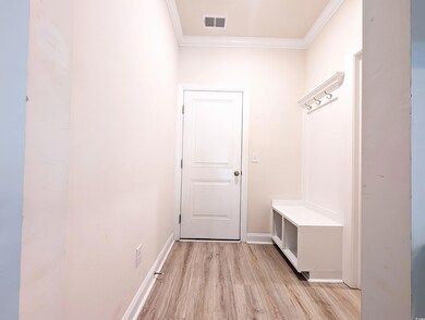 Mudroom with crown molding and light wood-style floors