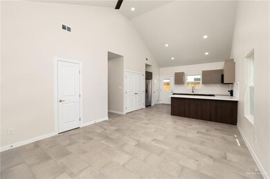 Kitchen featuring high vaulted ceiling, light countertops, a peninsula, recessed lighting, and backsplash