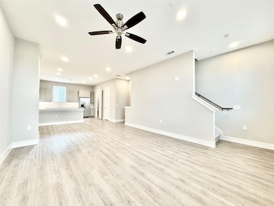 Unfurnished living room with ceiling fan and light