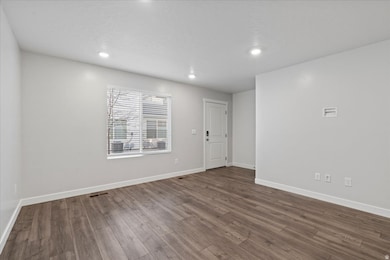 Unfurnished room featuring dark wood-style flooring and recessed lighting