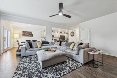 Living room with crown molding, dark LVP flooring,