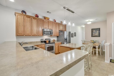 Kitchen with hanging light fixtures, appliances wi