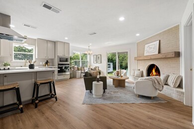 Living room with a notable chandelier, light hardw